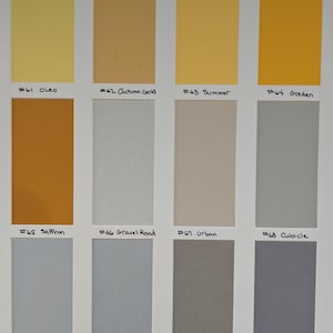 May include: A color swatch chart featuring twelve rectangular samples arranged in three rows. The colors include shades of yellow, gold, orange, beige, and various tones of gray. Each sample is labeled with a number and a name, such as #61 Oleo, #62 Autumn Gold, #63 Summer, #64 Golden, #65 Saffron, #66 Gravel Road, #67 Urban, #68 Cubicle, #69 Morning, #70 Kensington, #71 Fuzz, and #72 Steel Drum.