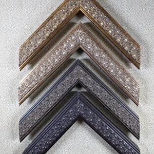 May include: Four picture frames with ornate, decorative, floral designs. The frames are arranged in a pyramid shape, with the largest frame at the top and the smallest frame at the bottom. The frames are made of wood and are painted in different shades of brown and black.