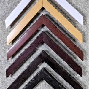 May include: A set of seven picture frames with different colored wood frames. The frames are arranged in a pyramid shape, with the largest frame at the top and the smallest frame at the bottom. The frames are all made of wood and have a smooth finish. The colors of the frames are white, light brown, dark brown, black, and gray.