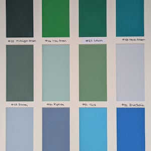 May include: A color swatch chart featuring twelve rectangular samples arranged in a grid. Each sample is labeled with a number and a name: #25 Midnight Green, #26 Irish Green, #27 Lawn, #28 Aqua Green, #29 Blarney, #30 Riptide, #31 Turf, #32 Blue Satin, #33 French Blue, #34 Biscay Blue, #35 Bluebird, and #36 Cabana.