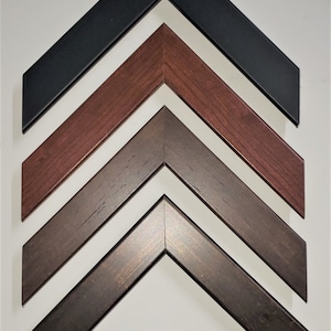 May include: Four picture frame corners in different wood finishes: black, dark brown, medium brown, and reddish brown.
