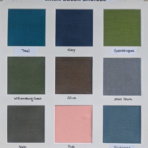 May include: A white display board titled LINEN COLOR CHOICES featuring nine square fabric swatches in teal, navy, grasshopper, williamsburg green, olive, steel drum, slate, pink, and bluestone, each labeled with its corresponding color name.