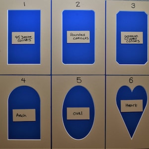 May include: Six beige rectangular picture mats with blue centers, numbered one through six. Each mat features a unique cutout shape: 45 degree corners, rounded corners, octagon clipped corners, arch, oval, and heart, with labels for each.