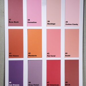 May include: A color chart with 12 paint swatches, each with a number and a name. The colors range from light pink to dark red. The names include Rose Bush, Carnation, Bandage, Cotton Candy, Hot Sauce, Mandarin, Fiji Coral, Sushi, Las Cruces Purple, Grey Violet, All American Red, and Brick.