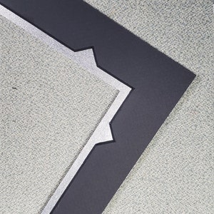 May include: A black picture frame with a silver border. The frame has a decorative, geometric design.