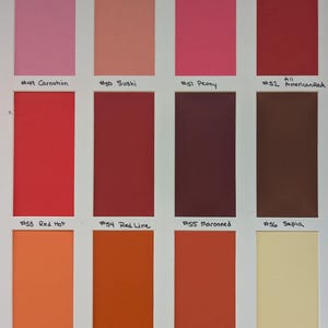 May include: A color swatch chart featuring twelve rectangular samples arranged in three rows. Colors include pink, coral, red, maroon, brown, orange, and cream. Each swatch is labeled with a number and name, such as #49 Carnation, #50 Sushi, #51 Peony, #52 American Red, #53 Red Hot, #54 Red Line, #55 Marooned, #56 Sepia, #57 Mandarin, #58 Orange Ade, #59 Hot Sauce, and #60 Omelet.
