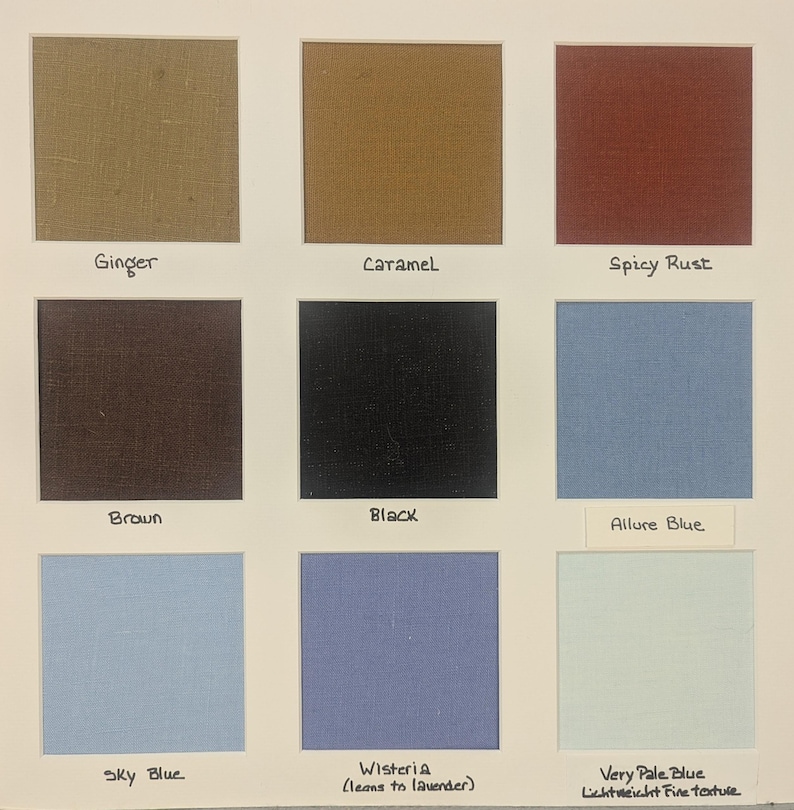 May include: A fabric color swatch card featuring nine square samples in ginger, caramel, spicy rust, brown, black, allure blue, sky blue, wisteria, and very pale blue. Each square is labeled with its corresponding color name in black ink.