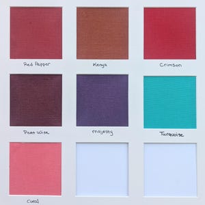 May include: A grid of eight fabric swatches mounted on a white board, labeled Red Pepper, Kenya, Crimson, Port Wine, majesty, Turquoise, and Coral. Each square displays a distinct solid color with a visible woven texture, arranged in a three-by-three layout.