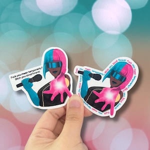 Könnte beinhalten: Zwei Aufkleber mit einer stilisierten Illustration einer Person mit blau-rosa Haaren, Sonnenbrille und Mikrofon. Die Aufkleber haben den Text "Fuck you mean temporarily? Bitch you blind foreva!"