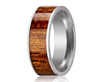 May include: A ring featuring a polished silver-toned metal band with a wide inlay of dark brown wood grain. The wood inlay runs horizontally around the center of the band, framed by smooth, reflective silver-toned metal edges on both sides.