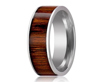 May include: A ring featuring a polished silver-toned metal band with a wide, flat inlay of dark brown wood grain running along the center. The metal edges are smooth and reflective, contrasting with the natural texture of the wood inlay.