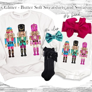 May include: A white sweatshirt with a glittery design of three nutcracker soldiers. The sweatshirt is paired with a white onesie with a similar design and a pink bow headband.