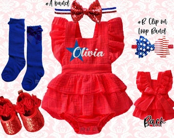 May include: Red and white star-themed baby outfit with a personalized name "Olivia" on the front. The outfit includes a red ruffled dress, blue knee-high socks, red sparkly shoes, and two red, white, and blue hair bows.