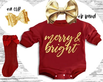 May include: Red baby onesie with gold glitter lettering that says "merry & bright". The onesie is paired with a gold glitter bow hair clip and a red knit bow leg warmer.