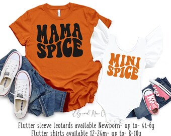 May include: A set of two shirts featuring the text "Mama Spice" and "Mini Spice" in a retro font. The shirts are orange and white and are available in a range of sizes for adults and children. Flutter sleeve leotards available Newborn- up to 4t-by Flutter shirts available 12-24m- up to 8-10y