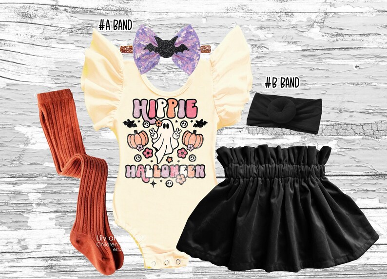 A flat lay of a children's Halloween outfit including a cream romper with a Hippie Halloween graphic, a black velvet skirt, rust-colored tights, a black headband, and a sparkly purple bow with a black bat.