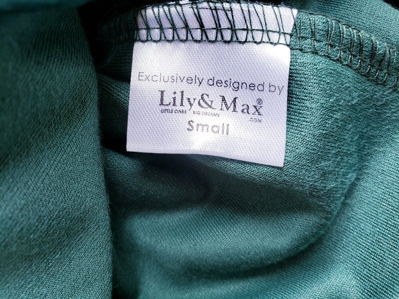 May include: White tag with black text that reads "Exclusively designed by Lily & Max Little Ones Big Dreams .com" and "Small" on a green fabric.