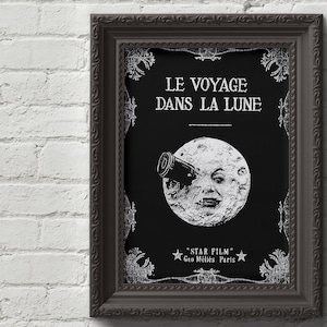 Puede incluir: Un p&oacute;ster de pel&iacute;cula vintage en blanco y negro con una cara de luna mirando a trav&eacute;s de un telescopio. El p&oacute;ster dice "LE VOYAGE DANS LA LUNE" y "STAR FILM Geo Melies Paris".