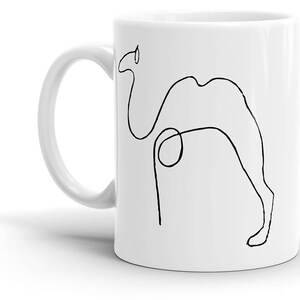 May include: White ceramic mug with a black line drawing of a camel on one side. The camel is drawn in a simple, minimalist style.