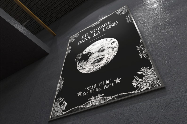 Puede incluir: Un p&oacute;ster en blanco y negro con el t&iacute;tulo "Le Voyage Dans La Lune" y un dibujo de la cara de un hombre en la luna. El texto "Star Film" y "Geo Melies Paris" tambi&eacute;n est&aacute; en el p&oacute;ster.