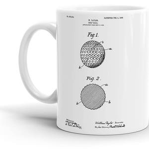 Puede incluir: Taza de cerámica blanca con una ilustración en blanco y negro de una patente de bola de golf. La patente se titula "W. Taylor Golf Ball" y la fecha de la patente es "Patentado el 4 de febrero de 1904".