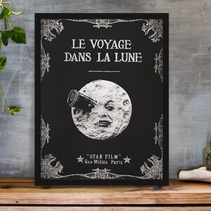 Puede incluir: Un p&oacute;ster en blanco y negro con un dise&ntilde;o vintage que presenta una luna con una cara y un telescopio. El texto en el p&oacute;ster dice "Le Voyage Dans La Lune" y "Star Film Geo Melies Paris".
