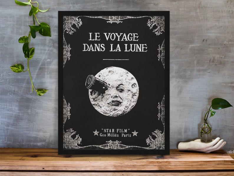 Puede incluir: Un p&oacute;ster en blanco y negro con un dise&ntilde;o vintage que presenta una luna con una cara y un telescopio. El texto en el p&oacute;ster dice "Le Voyage Dans La Lune" y "Star Film Geo Melies Paris".