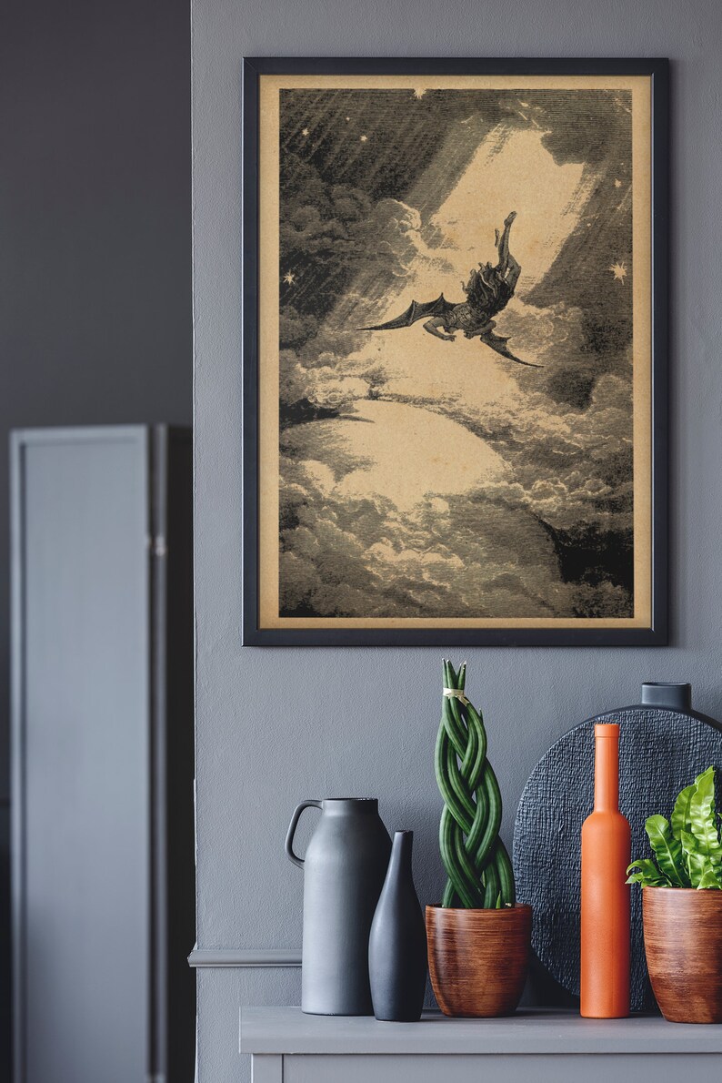 Puede incluir: Impresi&oacute;n vintage enmarcada que representa una figura alada cayendo a trav&eacute;s de las nubes, iluminada por un rayo de luz. La obra de arte est&aacute; en tonos sepia, sobre un fondo oscuro. Debajo, hay objetos decorativos.