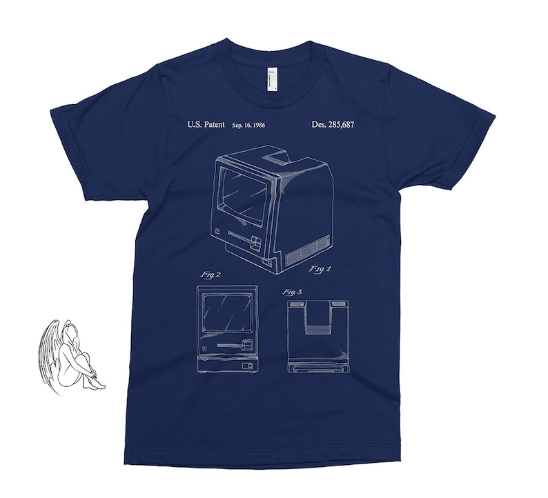 Puede incluir: Una camiseta azul marino con un contorno blanco de un dise&ntilde;o de computadora vintage. El dise&ntilde;o incluye el texto "U.S. Patent Sep. 16, 1986 Des. 285,687" y "Fig. 1", "Fig. 2" y "Fig. 3".