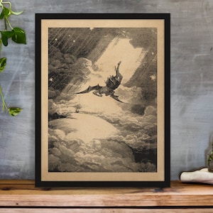 Puede incluir: Ilustraci&oacute;n en blanco y negro enmarcada que representa una figura alada cayendo por un cielo nublado. La obra de arte, sobre un fondo beige, est&aacute; enmarcada en negro y descansa sobre una superficie de madera. La imagen evoca drama y fantas&iacute;a.