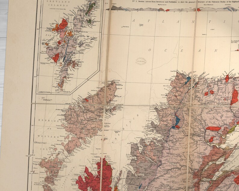 May include: A vintage map of Scotland, showing the geological formations of the country. The map is divided into sections, with each section showing a different geological feature. The map is printed in black and white, with red and blue lines indicating the different geological formations.