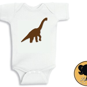 May include: White baby bodysuit with a brown dinosaur silhouette printed on the front.