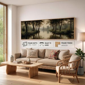 Puede incluir: Una impresi&oacute;n de arte mural panor&aacute;mico que muestra un r&iacute;o que fluye a trav&eacute;s de un bosque con &aacute;rboles reflejados en el agua. El marco tiene una profundidad de 4,3 cm, acabado en madera e incluye herrajes para colgar. El texto dice Art Nova Galeria.