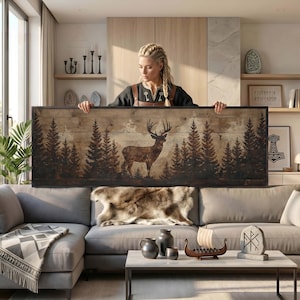 May include: A rectangular wall art piece featuring a dark brown silhouette of a stag standing in a forest of pine trees, printed on a light brown horizontal wood plank background, enclosed within a thin black frame.