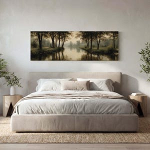 Puede incluir: Un cuadro panor&aacute;mico de paisaje que muestra un r&iacute;o tranquilo que fluye a trav&eacute;s de un bosque con &aacute;rboles de color verde oscuro y sus reflejos en el agua, colocado sobre una cama tapizada en beige con ropa de cama blanca y dos mesitas de noche.