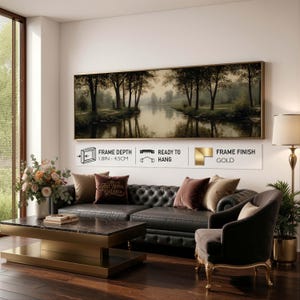 Puede incluir: Un cuadro panor&aacute;mico de paisaje que muestra una serena escena fluvial con &aacute;rboles oscuros y reflejos. La obra tiene un acabado de marco dorado, una profundidad de 4,5 cm y herrajes para colgar. El texto dice Frame Depth 1.8in - 4.5cm, Ready to Hang y Frame Finish Gold.