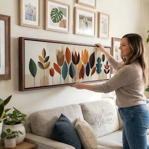 Könnte beinhalten: Ein langes, horizontales, rechteckiges Wandbild mit einer stilisierten botanischen Illustration verschiedener Blätter und tulpenartiger Blumen in Orange-, Petrol-, Dunkelblau- und Brauntönen auf cremefarbenem Hintergrund.