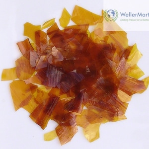 May include: A pile of amber-colored, translucent, irregularly shaped resin flakes.