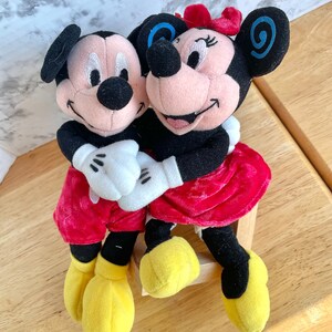 Mickey Minnie Mouse Hugging plushie doll, holding hands, blue swirls  on ears, smiling.