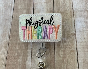 May include: A white glitter badge holder with a rainbow embroidered "physical therapy" text.