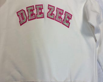 Delta Zeta Cream Mock Neck sweatshirt. Greek Pink Background and green and pink print Foreground letters
