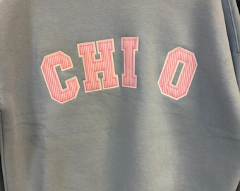 Chi OMega Mock Neck light blue sweatshirt   White Background and pink seersucker print Foreground letters