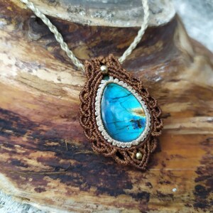May include: A brown and white macrame necklace with a blue labradorite gemstone pendant.