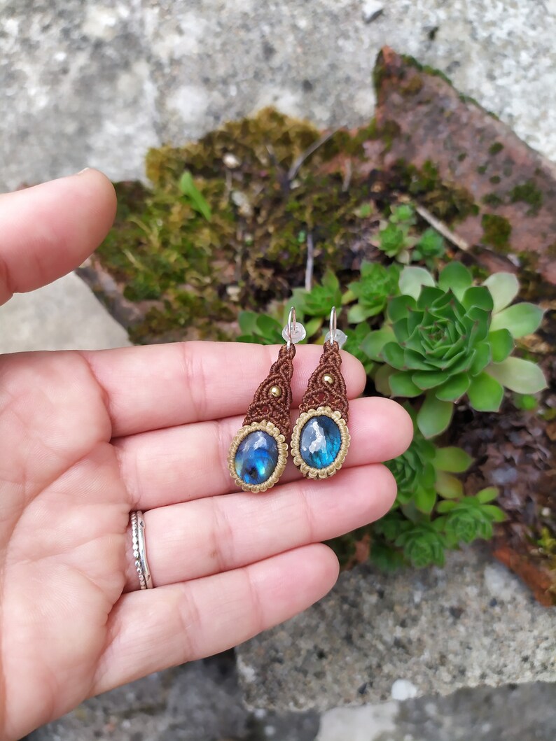 May include: A pair of brown and gold macrame earrings with blue labradorite gemstone drops.