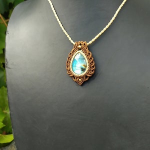 May include: A brown macrame necklace with a teardrop-shaped blue labradorite gemstone pendant.