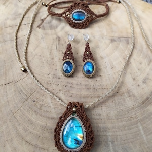 May include: A set of jewelry featuring a brown macrame necklace, bracelet, and earrings with iridescent blue labradorite stones.