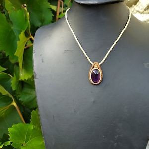 May include: A purple amethyst gemstone pendant necklace with a brown leather cord and a white macrame cord.