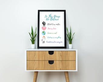 May include: A framed print with the text "In This House We Believe" and a list of values including "Black Lives Matter", "Love is Love", "Science is Real", "Kindness is Everything", and "Freedom is for Everyone".