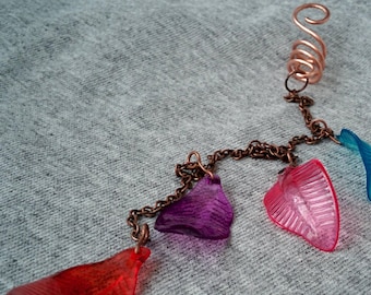 May include: A copper hair chain with a spiral wire at the top and five dangling plastic charms in shades of red, pink, purple, and blue.