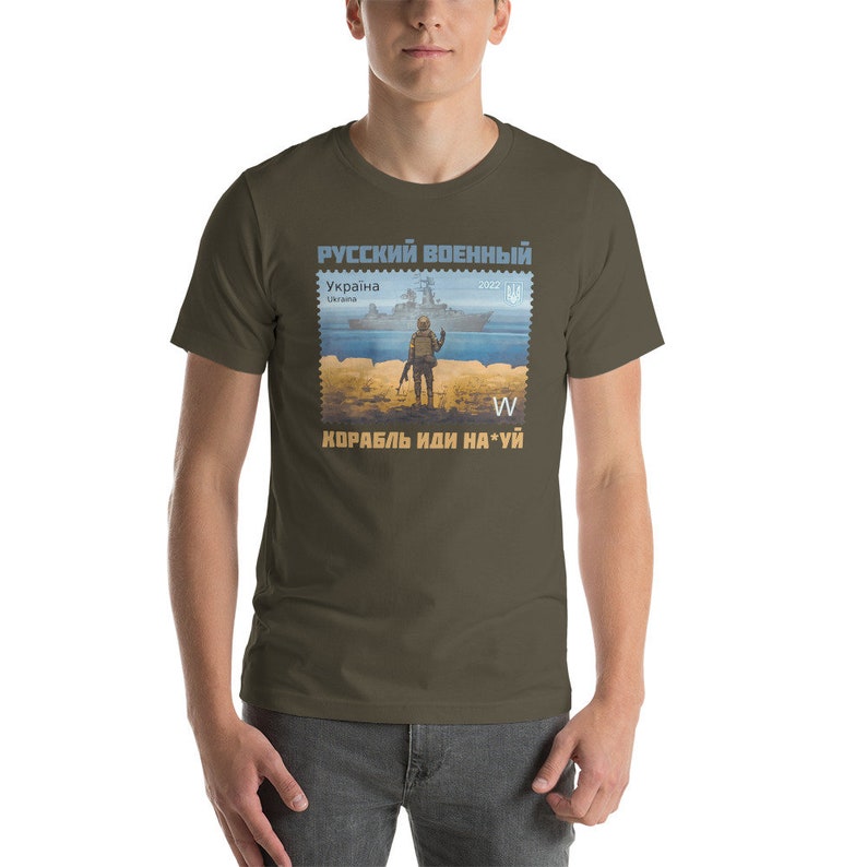 May include: Olive green t-shirt featuring a postage stamp design with a soldier, a warship, and text in Russian and Ukrainian. The stamp design includes the text "Russian Military" and "Ukraine".